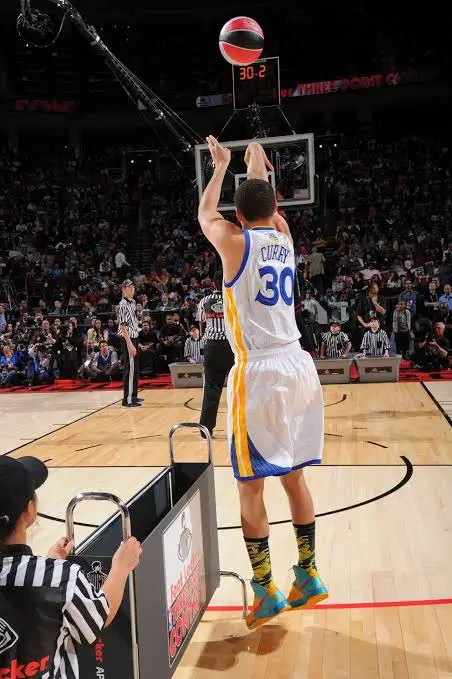 Image showing the lower body of a basketball player during a jump shot, with feet positioned pointing towards 10 to 11 o'clock, demonstrating the optimal toe alignment for shooting, similar to the technique used by professional basketball players like Steph Curry.