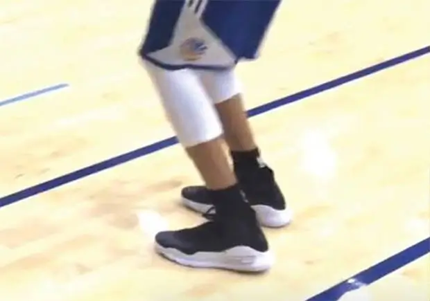 Image showing the lower body of a basketball player during a jump shot, with feet positioned pointing towards 10 to 11 o'clock, demonstrating the optimal toe alignment for shooting, similar to the technique used by professional basketball players like Steph Curry.